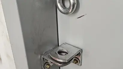 תמונה של מנגנון נעילה לדלת ממד, כולל צילינדר ומסילות מתכתיות.