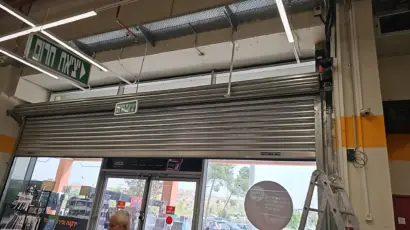 תמונה של דלת ממד סגורה עם שלט "יציאת חנות" ומשטח עבודה ליד.